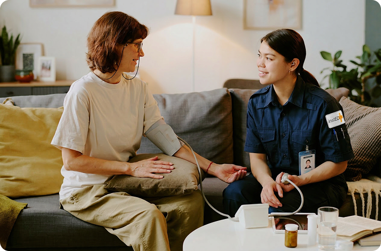 insted worker taking a womans blood pressure from her couch