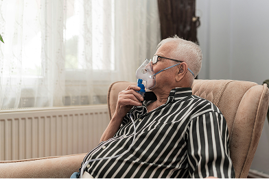man using breathing device at home
